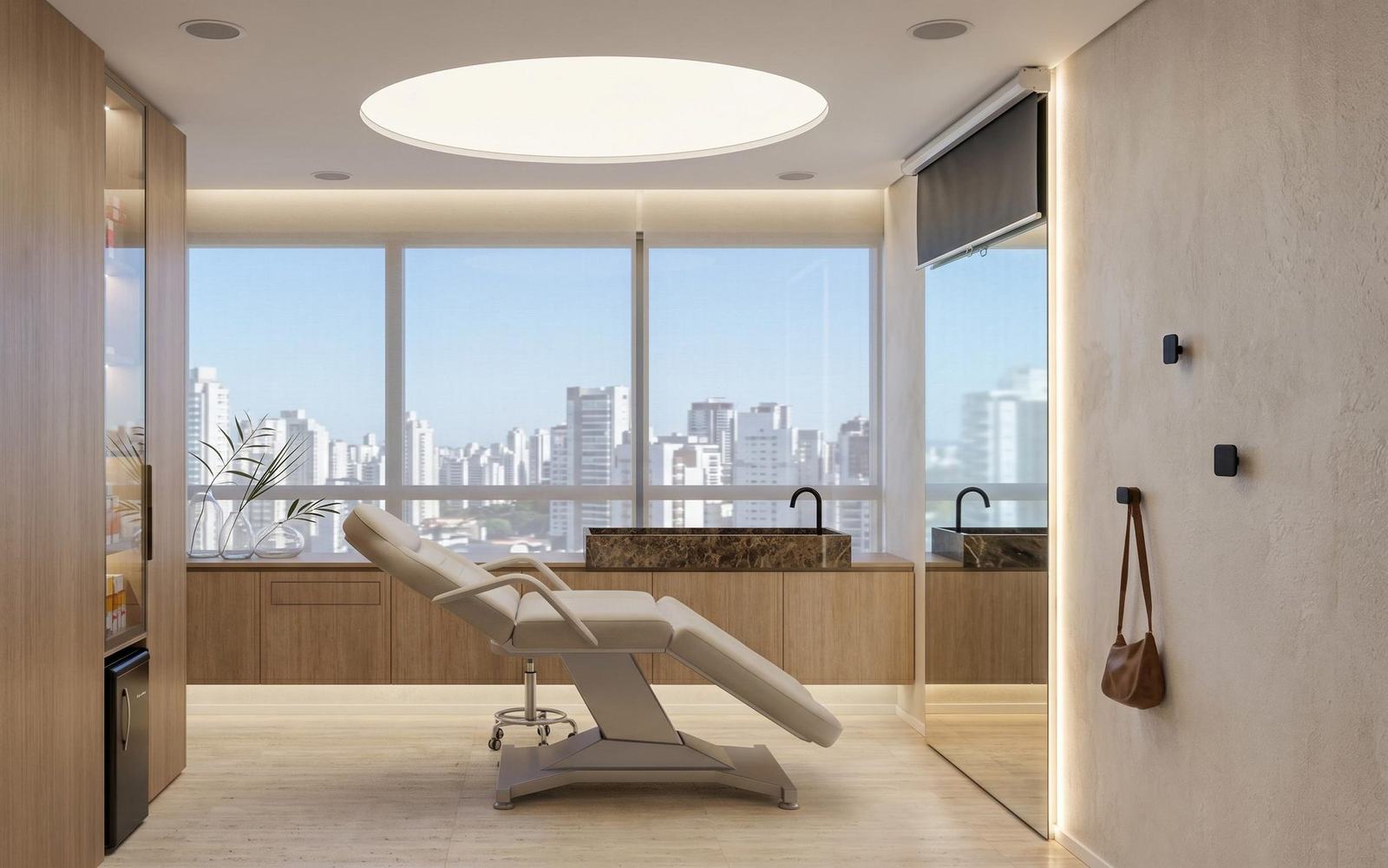Consultório de dermatologia: maca creme, bancada de mármore marrom, teto circular iluminado e janela com a cidade.